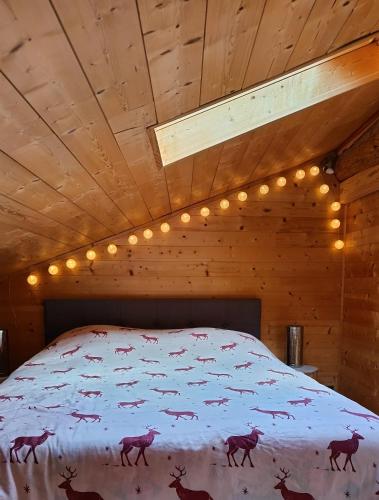 a bedroom with a bed with deer on it at Appartement mansardé cocooning in Saint-Martin-Vésubie