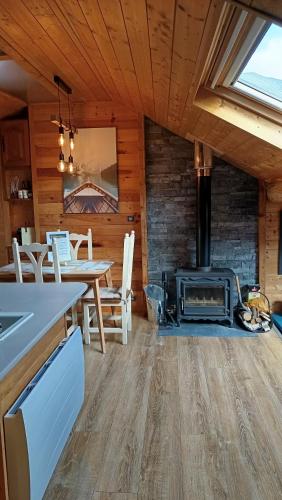 une cuisine et une salle à manger avec un poêle à bois dans l'établissement Appartement mansardé cocooning, à Saint-Martin-Vésubie
