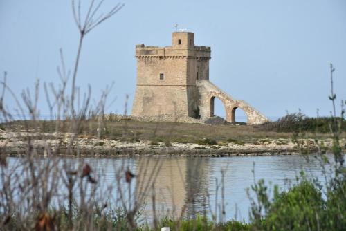 an old tower on an island in the water at Hotel Villa del Sole in Porto Cesareo