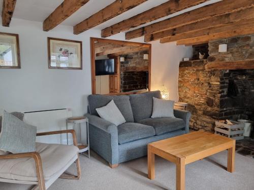 a living room with a couch and a table at Roses Cottage and Studio in Bideford