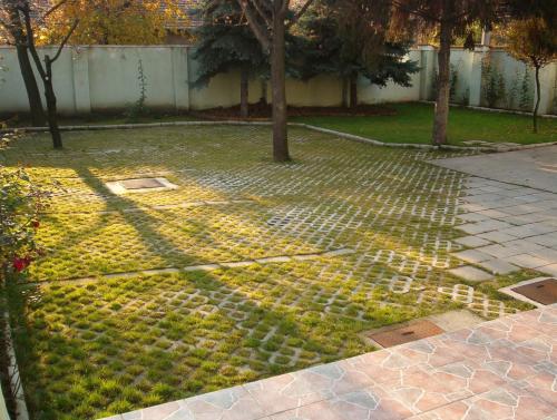a garden with trees and a brick sidewalk at Jáde Panzió in Budapest