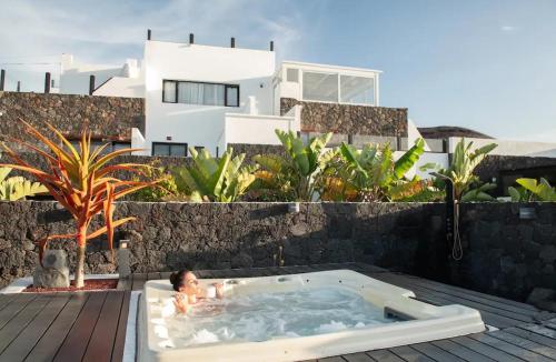 a child in a jacuzzi tub in front of a house at Finca Marisa in Tinajo