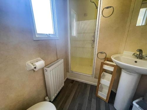 une salle de bain avec un lavabo, des toilettes et une douche dans l'établissement Brilliant 8 Berth Caravan At Valley Farm Holiday Park, Essex Ref 46443V, à Great Clacton