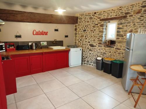 a kitchen with red cabinets and a white refrigerator at La Ferme d' Emerentine in Bacilly
