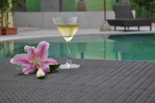 a glass of wine and a flower on a table at Mountain Creek Wellness Resort Chiangmai in Chiang Mai