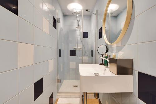 a bathroom with a white sink and a mirror at Hôtel Cocoon in Saint-Ouen