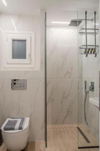 a bathroom with a toilet and a glass shower at City Lodge in Thessaloniki