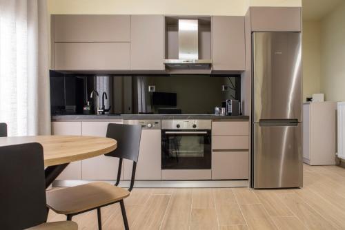 a kitchen with a table and a stainless steel refrigerator at City Lodge in Thessaloniki
