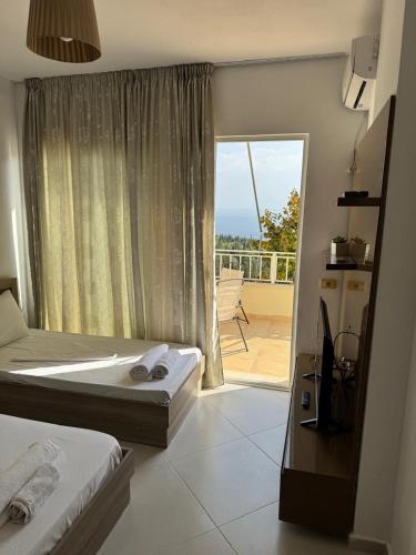 a hotel room with two beds and a balcony at Natali Apartments in Gjilek