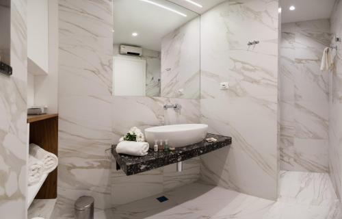 Baño blanco con lavabo y espejo en Residence by Vestibul Palace en Split