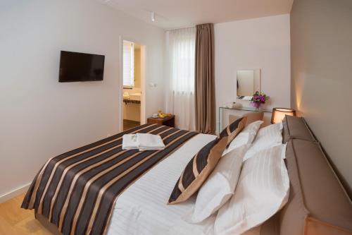 um quarto de hotel com uma cama com um cobertor listrado em Residence by Vestibul Palace em Split