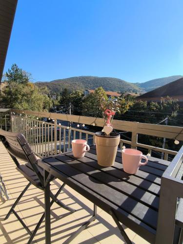 a table with two mugs on it on a balcony at Smestaj Dzentlmen in Soko Banja