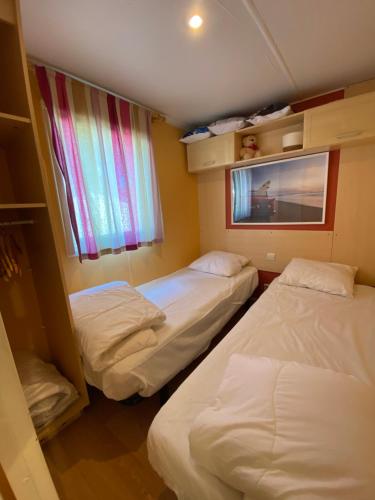 a room with two beds and a window in it at Le Lolipop in Capbreton
