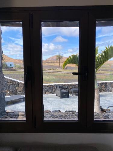 a window with a view of a palm tree outside at Finca Marisa in Tinajo
