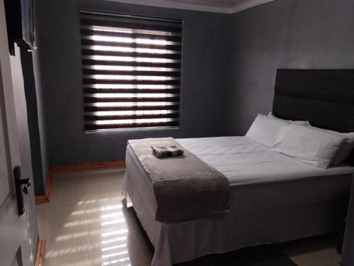 a bedroom with a large bed with a window at Monarca inn - Affordable Accomodation in makwane molapo location Qwaqwa in Phuthaditjhaba
