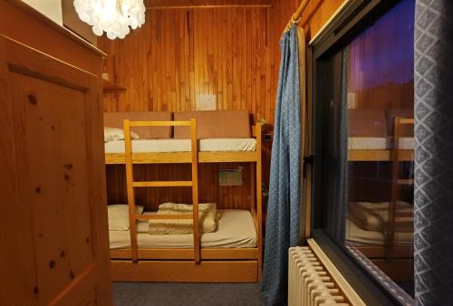 une chambre avec deux lits superposés et une fenêtre dans l'établissement MyHome - Génépis 35 - Duplex 6 pax skis aux pieds - Val Claret, à Tignes