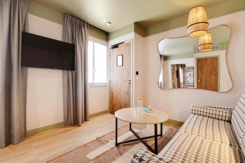 a living room with a couch and a table at Hôtel Cocoon in Saint-Ouen