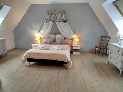 a bedroom with a bed with a canopy at La Ferme d' Emerentine in Bacilly