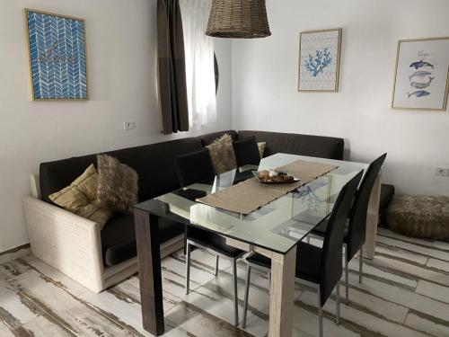 a dining room with a glass table and a couch at Finca Marisa in Tinajo