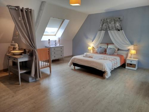 a bedroom with a bed and a desk and a window at La Ferme d' Emerentine in Bacilly