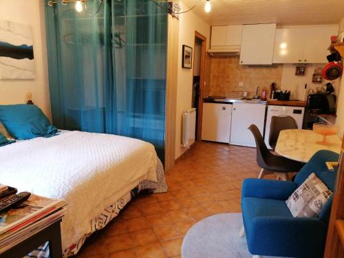 une petite chambre avec un lit et une cuisine dans l'établissement Studio en rez de chaussée, avec jardin partagé., à Vars