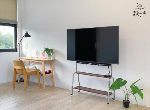 a flat screen tv on a stand in a living room at Still Hills Inn in Hengchun