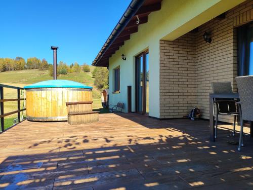 a wooden deck with a gazebo next to a building at Dom na Słonnym in Manasterzec