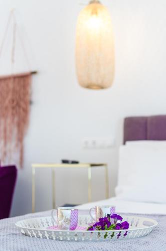 a plate on a table with purple flowers on it at Comfort Rooms by MaliaMare Hotel in Malia