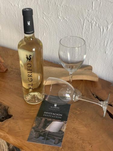 a bottle of wine and a glass on a wooden table at Finca Marisa in Tinajo