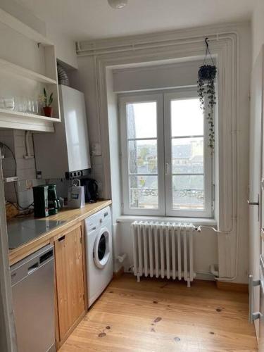une cuisine avec une machine à laver et une fenêtre dans l'établissement La PetiteVillaise, à Granville