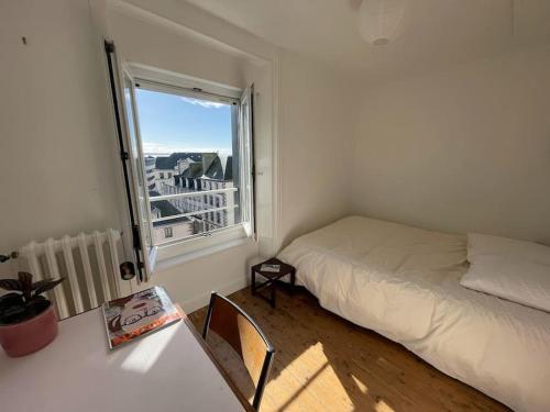 ein kleines Schlafzimmer mit einem Bett und einem Fenster in der Unterkunft La PetiteVillaise in Granville