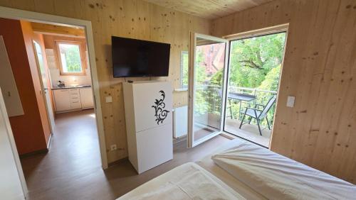 a room with a tv on a wall with a refrigerator at Natur Apartments Natalia in Fürth