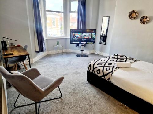 a bedroom with a bed and a chair and a desk at West Beck House Newcastle - Spacious Double Room in North Shields