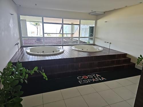 Ein Badezimmer mit zwei Badewannen auf einer schwarzen Waschtischplatte in der Unterkunft Ap70 m2 condomínio luxo Costa Espanha- Salvador- pré Carnaval -Réveillon em praia exclusiva- Vista Mar in Salvador