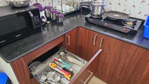 a kitchen counter with a drawer filled with utensils at Chippy Apartments No 56 in Chennai