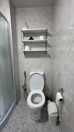 a bathroom with a white toilet and a shower at Comfortable place with fully equipped in Angisa