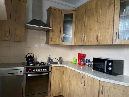 a kitchen with wooden cabinets and a stove and a microwave at Apartament przy Parku Czartoryskich - Faktury VAT - parking in Puławy