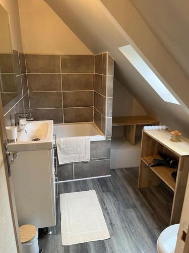 La salle de bains mansardée est pourvue d'un lavabo et de toilettes. dans l'établissement La Voûte, à Kerfot