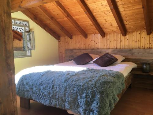 une chambre avec un lit dans une pièce en bois dans l'établissement Comme à la maison, à Fillinges