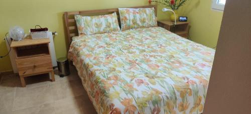 a bedroom with a bed with a floral bedspread at Villa Kathy in Los Altos