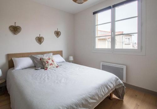 a bedroom with a white bed with a teddy bear on it at Gites 4 et 6 personnes au cœur du centre médiéval de Billom in Billom