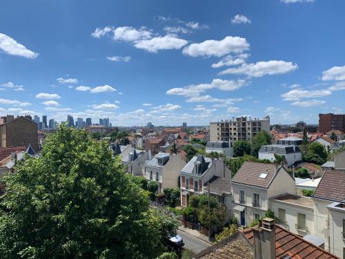 une vue d'une ville avec des bâtiments dans l'établissement Charme et haut standing - Vue sur La Défense, à Colombes