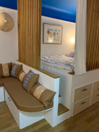 Cette chambre comprend un lit et un canapé avec des oreillers. dans l'établissement Charme et haut standing - Vue sur La Défense, à Colombes