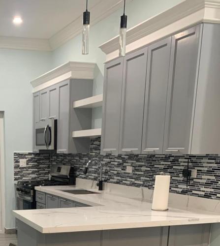 una cucina con mobili bianchi e un lavandino di Sunset Serenity a Nassau