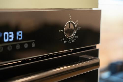 a close up of an oven with a clock on it at Apartament ZHana in Podgorica