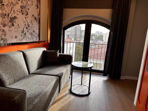 a living room with a couch and a table and a window at OTTO Tunalı Houses in Ankara