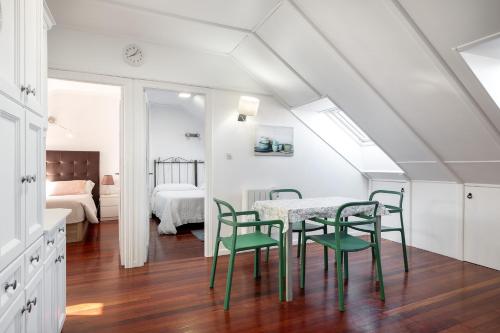 a dining room with a table and green chairs at El Puerto Llanes, apartamento para 4 personas in Llanes