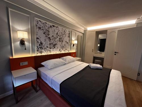 a small bedroom with a bed and a painting on the wall at OTTO Tunalı Houses in Ankara