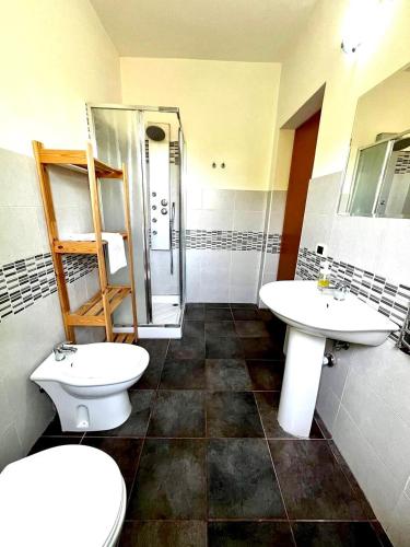 a bathroom with two sinks and a shower and a toilet at Case Di Loco Castro in Agnone Bagni