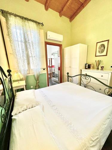 a bedroom with a large white bed in front of a window at Case Di Loco Castro in Agnone Bagni